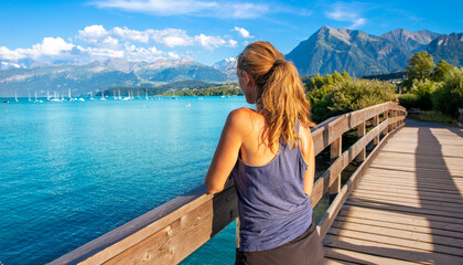 Fototapeta na wymiar Woman tourist looking at beautiful lake in Switzerland