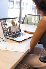 Composition of biracial businesswoman having video call with colleagues in office