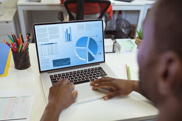 Composition of african american businessman using laptop with data processing