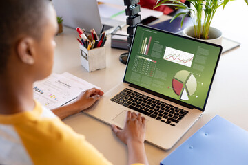 Composition of african american businessman using laptop with data processing