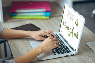 Caucasian businesswoman using laptop with data processing