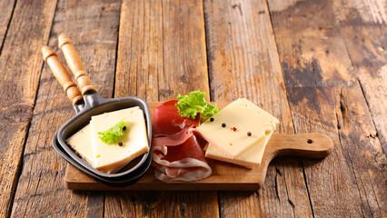 raclette cheese and prosciutto ham on board