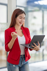 Excited happy woman looking at the tablet screen, celebrating an online win, overjoyed young asian female screaming with joy, isolated over a white blur background
