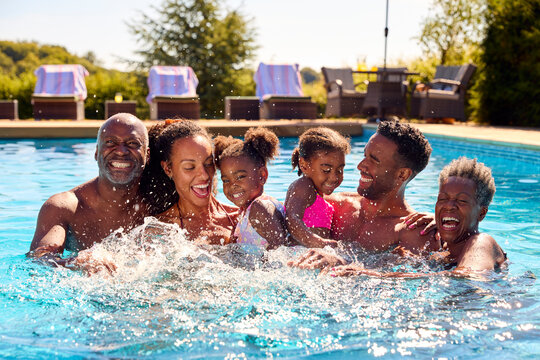 Portrait Of Smiling Multi-Generation Family On Summer Holiday Relaxing In Swimming Pool