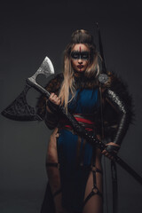 Shot of warrior woman with make up dressed in attire and fur looking at camera.