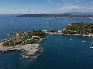 Fototapeta na wymiar Aerial view of Cap d'Antibes and Billionaire's Bay. Beautiful rocky beach near coastal path on the Cap d'Antibes, Antibes, France. Drone view from above of Côte d’Azur near Juan-les-Pins and Cannes.