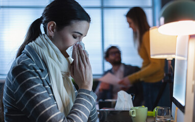 Woman working in the office and having a cold