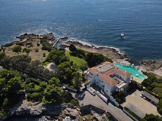 Aerial view of Cap d'Antibes and  Billionaire's Bay. Beautiful rocky beach near coastal path on the Cap d'Antibes, Antibes, France. Drone view from above of Côte d’Azur near Juan-les-Pins and Cannes.