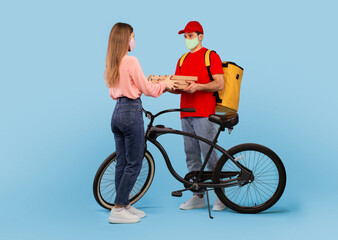 Male Courier Delivering Pizza Boxes To Woman On Blue Background