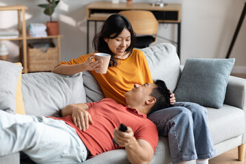 Obraz premium Positive japanese man and woman spending weekend together at home