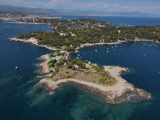 Obraz premium Aerial view of Cap d'Antibes and Billionaire's Bay. Beautiful rocky beach near coastal path on the Cap d'Antibes, Antibes, France. Drone view from above of Côte d’Azur near Juan-les-Pins and Cannes.