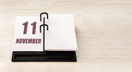 november 11. 11th day of month, calendar date. Stand for desktop calendar on beige wooden background. Concept of day of year, time planner, autumn month