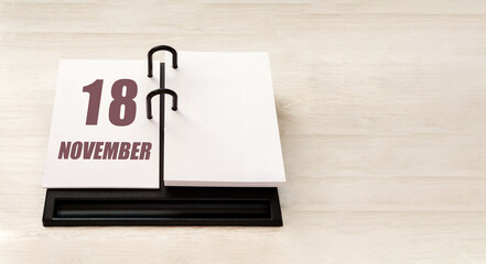 november 18. 18th day of month, calendar date. Stand for desktop calendar on beige wooden background. Concept of day of year, time planner, autumn month