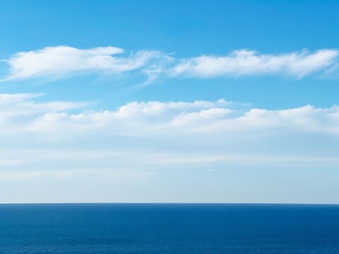 Blue sea water and sky clouds.