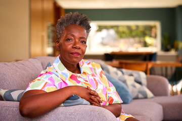 Portrait Of Retired Serious Senior Woman Sitting On Sofa At Home