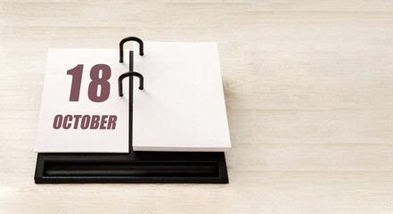 october 18. 18th day of month, calendar date. Stand for desktop calendar on beige wooden background. Concept of day of year, time planner, autumn month
