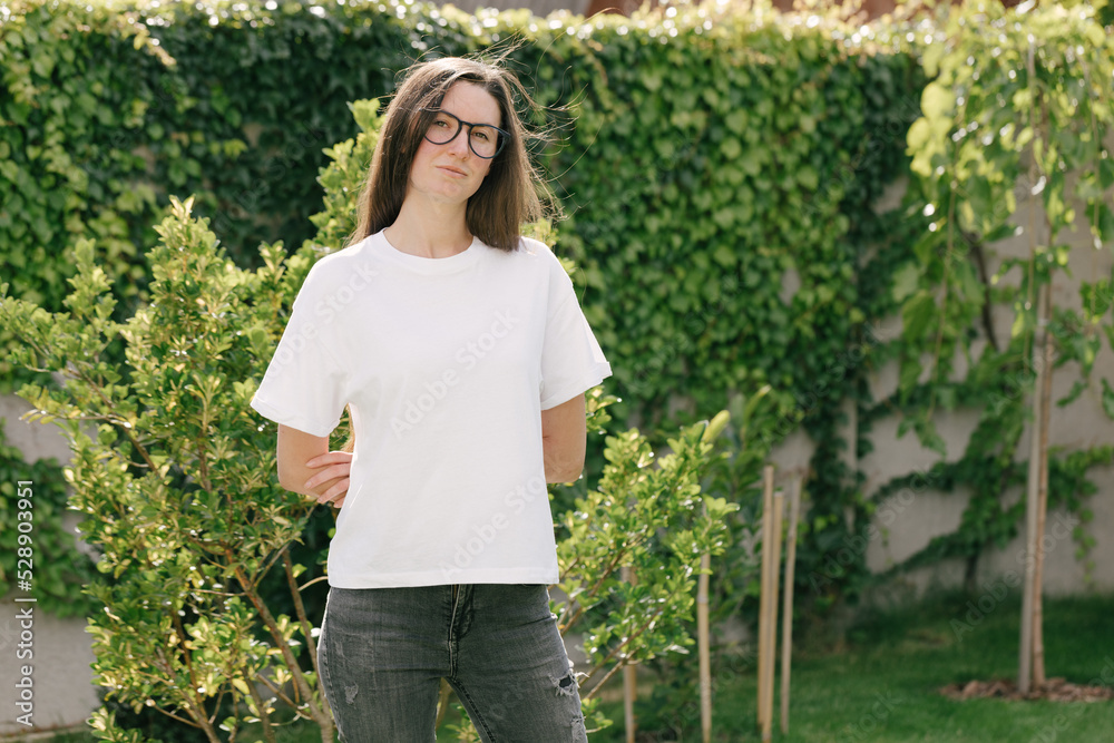 Wall mural Woman wearing white t-shirt with space for logo or design in the park in summer