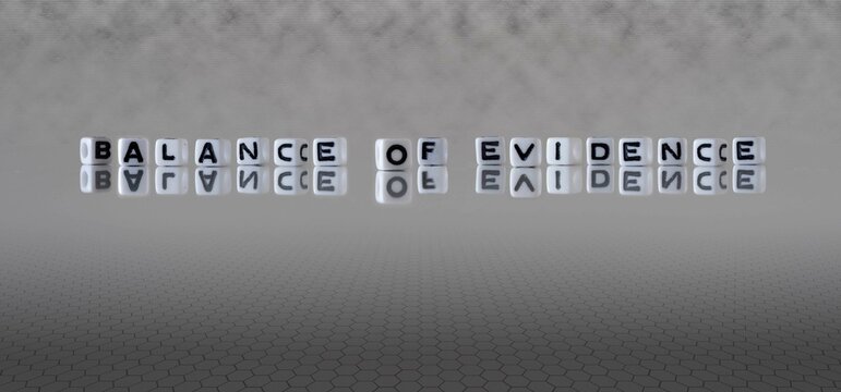 balance of evidence word or concept represented by black and white letter cubes on a grey horizon background stretching to infinity
