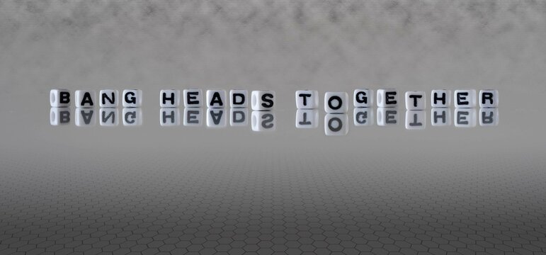 bang heads together word or concept represented by black and white letter cubes on a grey horizon background stretching to infinity