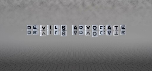 devils advocate word or concept represented by black and white letter cubes on a grey horizon...