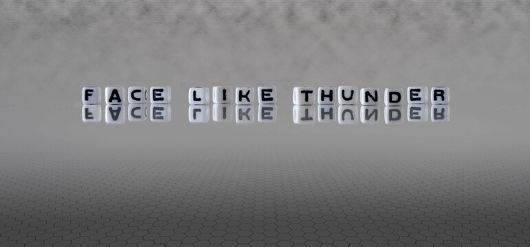 face like thunder word or concept represented by black and white letter cubes on a grey horizon background stretching to infinity