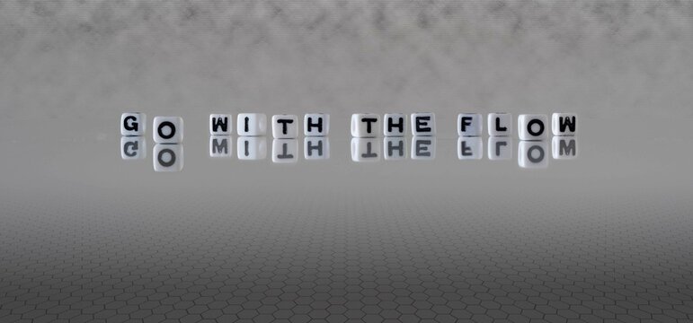 go with the flow word or concept represented by black and white letter cubes on a grey horizon background stretching to infinity