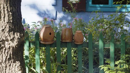 Clay pots on the wooden fence. Colourful hut from XIX century.