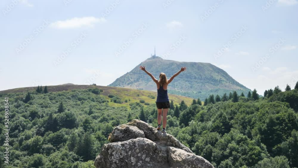 Wall mural hiker woman enjoying panorama view of mountain (puy de dome, auvergne in france)