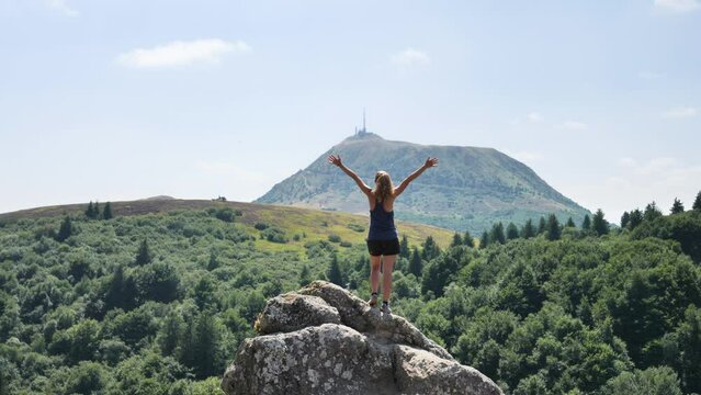 hiker woman enjoying panorama view of mountain (puy de dome, auvergne in france)
