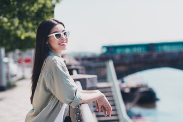 Fototapeta premium Photo of dreamy sweet lady dressed casual clothes dark glasses walking enjoying sunshine outside urban embarkment