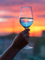 A glass of wine in hand, a beautiful sunset outside the window