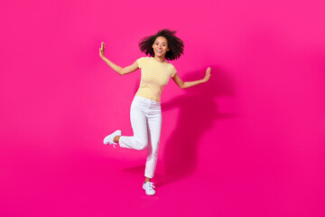 Full body photo of nice young girl dance festival event have fun wear trendy yellow striped outfit isolated on vivid pink color background