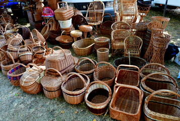 A close up on a huge set of wicker baskets and other containers arranged in sets and displayed to people during one of medieval and folk fairs organized in Poland during summer