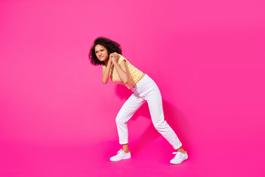 Full body size photo of young attractive gorgeous nice girl drag pull hard heavy object empty space isolated on pink color background