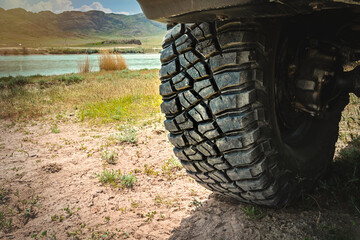 Big wheel 4x4 SUV with aggressive tread on a trip in the wild.