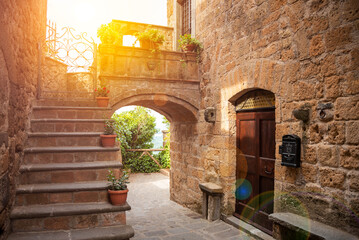 Fototapeta na wymiar Picturesque building in medieval town in Tuscany, Italy. Old stone walls and plants