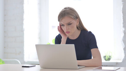 Woman having Headache while Working on Laptop