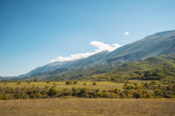 Fototapeta premium plowed field against the background of mountains in Albania. Agricultural landscape