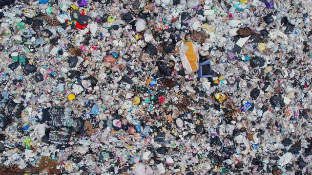 Aerial view from a drone flying over a large pile of garbage,  Lots of plastic bottles and plastic waste. environmental Issues. household waste. global problem. 4k
