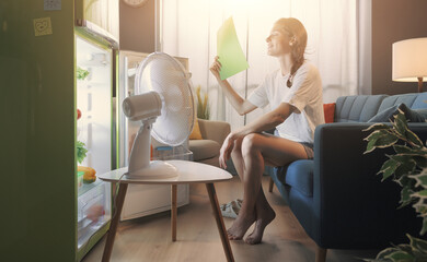 Woman at home during the summer heatwave - obrazy, fototapety, plakaty