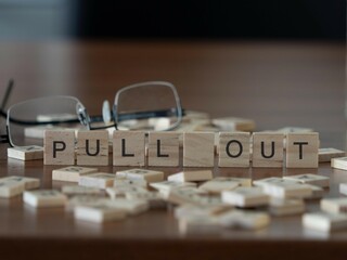 pull out word or concept represented by wooden letter tiles on a wooden table with glasses and a...