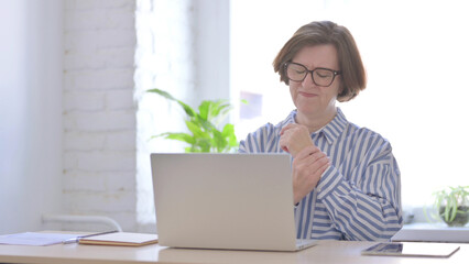 Senior Woman having Wrist Pain while using Laptop