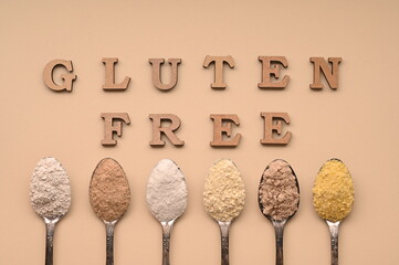 Gluten free text and spoons of various gluten free flour. Flat lay, top.