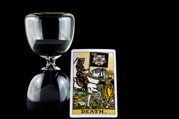 Hourglass with Death Tarot Card Isolated on a Black Background