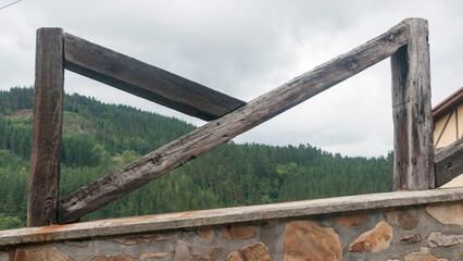 Fototapeta premium Valla rústica de tablones de madera en casa rural junto a bosque en colina