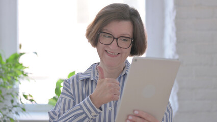 Portrait of Senior Woman Celebrating on Tablet in Office