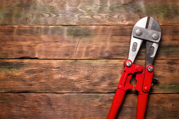 Bolt cutters rebar shears on wooden workbench background. Top view.