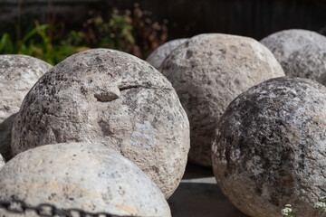 Large vintage stone cannon balls on a blurred background