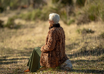 woman in a astrakhan fur coat on a cold autumn day looks into the distance