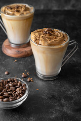 Dalgona coffee in glass cups. Dark moody backgroung with copy space